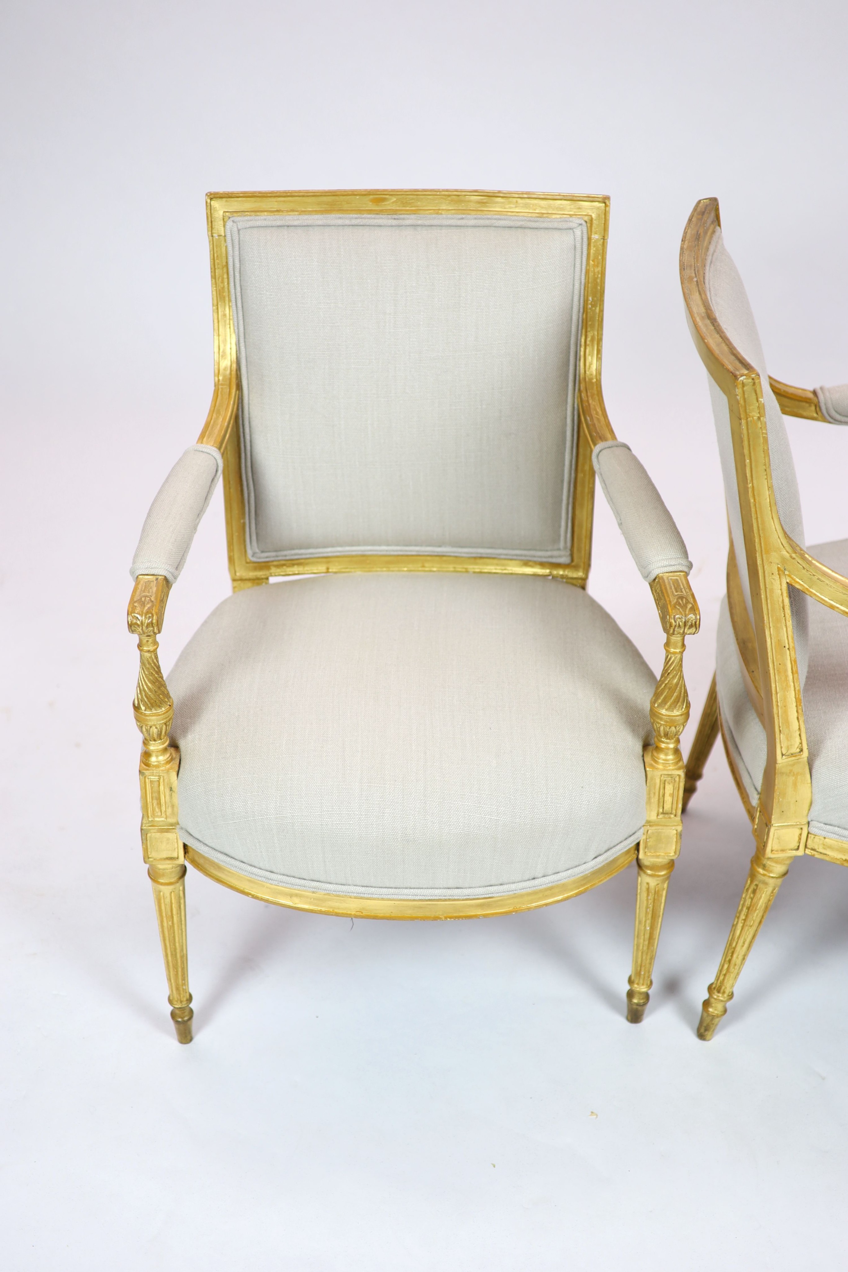 A pair of Louis XVI style giltwood elbow chairs H 89cm. W 59cm. D 60cm.